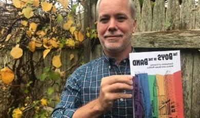 Professor Matt Bell holds up book he edited and contributed to